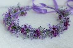 a purple flower crown on a white surface