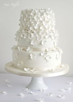 a white wedding cake with flowers on top