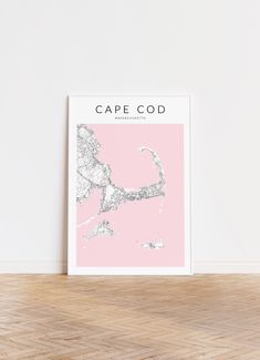 a pink and white poster with the words cape god on it in front of a wooden floor