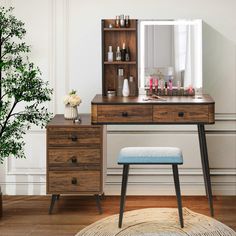 a desk with a mirror, stool and vase on it next to a potted plant