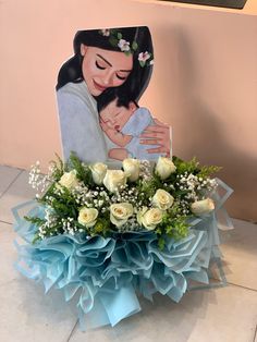 a bouquet of white roses and baby's breath in front of a photo