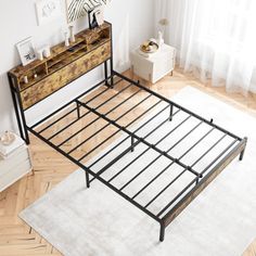 a bed with metal frame and wooden headboard in a room next to a window