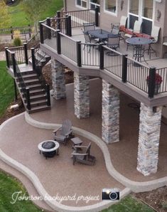 an outdoor patio with stone pillars and chairs on the deck, surrounded by lawn furniture