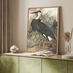 an image of a bird sitting on top of a table next to a book and vase