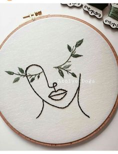 the embroidery is being worked on with scissors and thread to make it look like a woman's face