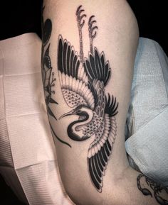 a woman's thigh with a bird tattoo on it