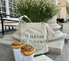 two pastries sitting on top of a table next to a bag and some flowers