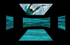 a man swimming in the ocean through an open window with multiple screens showing him from underwater level