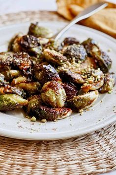 a white plate topped with brussel sprouts covered in nuts and seasoning