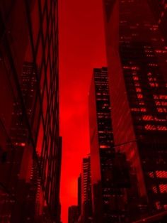 the sky is red and there are skyscrapers in the background