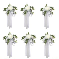 six white roses tied together with ribbon and greenery on each side, all in the same arrangement