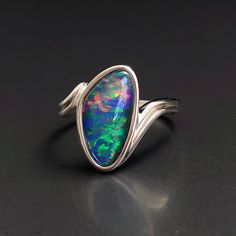 "Natural Australian black Opal triplet Sterling Silver Ring, one-off piece of natural opal set in sterling silver in a modern design.  Simple design with a pop of rainbow colour in this unique opal ring.  💎 Main Gemstone: Natural Australian Black Opal 💎 Material: Solid British Sterling Silver with rhodium plating.  Please note: All my Australian black Opals are one-off pieces so some rings will need to be resized to your size once the order is placed, please allow 4-5 working days for me to ch Black Cabochon Opal Ring, Silver Opal Ring With Polished Finish, Unique Opal Ring, Black Fire Opal, Rainbow Colour, Unique Opal, Natural Opal Ring, Australian Black Opal, Rings Black