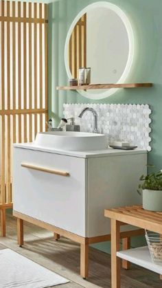 a white sink sitting under a bathroom mirror next to a wooden table and stools