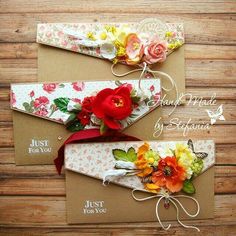 three envelopes decorated with flowers and ribbons