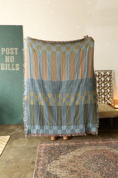 a blue and tan blanket sitting on top of a rug