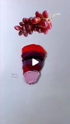 an image of grapes and lipstick on a white surface