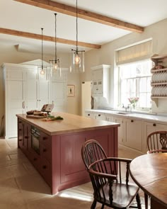 a kitchen with an island and wooden chairs