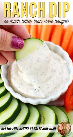 a hand dipping a cucumber into ranch dip