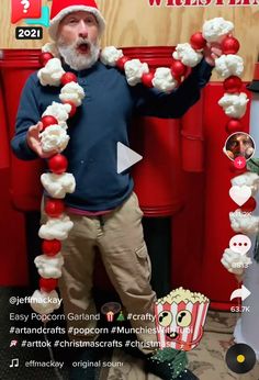 an old man wearing a santa hat and holding up some candy canes in front of him