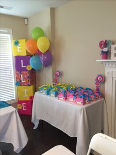 there is a table with balloons and gifts on it at a birthday party in the room