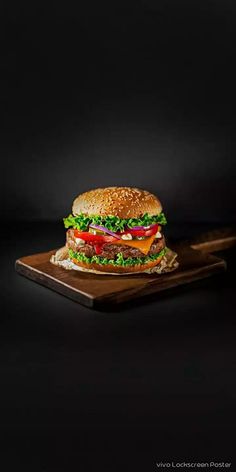 a cheeseburger with lettuce and tomato on a cutting board