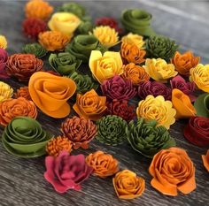 many different colored flowers on a wooden table