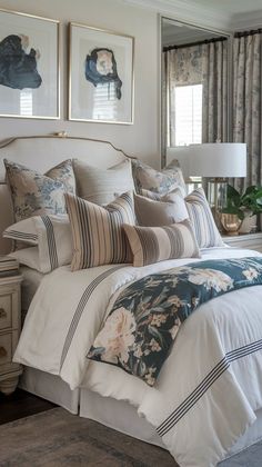 a bed with white and blue comforter in a bedroom next to two pictures on the wall