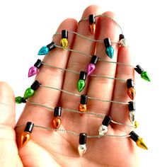 a hand is holding several small christmas lights