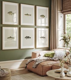 a living room with green walls and pictures on the wall above the couch, along with vases filled with flowers