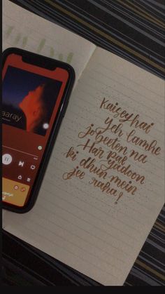 a cell phone sitting on top of an open notebook next to a handwritten note