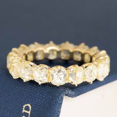 an antique diamond ring sits on top of a book