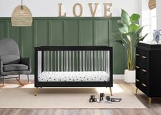 a baby's room with a crib, rocking chair and love sign on the wall