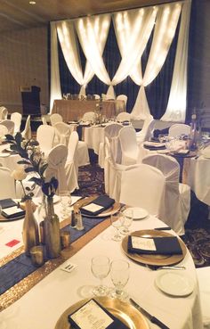 the tables are set up with white linens and gold place settings for an event