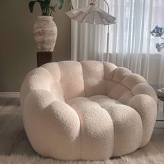 a large white chair sitting in front of a window