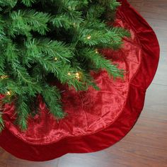 a green christmas tree on a red round ottoman