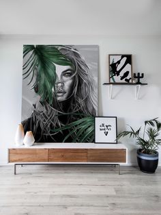 a black and white painting on the wall next to a plant