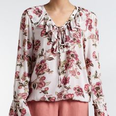 Make A Chic Statement With This Floral Print Top From Signature Studio. The Bell Sleeves, Lace-Up Details And Ruffle Accents Take This Look To The Next Level. **Size Small** Bust: 19" Length: 25" All Measurements Are Approximate Long Bell-Sleeves V-Neckline With Lace-Up Details Ruffle Accent 100% Rayon Machine Washable Feminine Spring Tops With Tie Neck, Feminine Tie Neck Tops For Spring, White Blouse With Floral Print And Ruffle Sleeves, White Ruffle Tie Neck Tops, White Ruffled Tie-neck Tops, White Ruffled Tie Neck Tops, Feminine Tie-neck Blouse For Day Out, Feminine Tie Neck Blouse For Day Out, Floral Print Tops