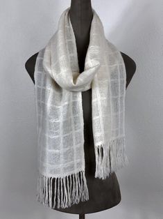 a white scarf with fringes on top of a mannequin dummyon stand