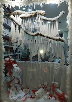 a window display with snow hanging from it's sides and presents on the windowsill