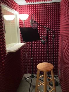 a recording studio with microphones, lights and sound boards on the wall next to a stool