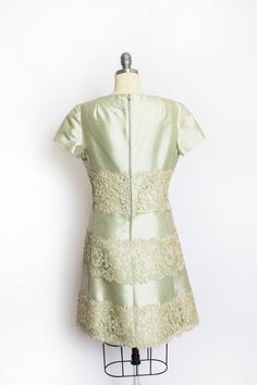 "Vintage 60s cocktail dress in lovely sea foam green with with fine chantilly lace overlay. A-line silhouette with short sleeves and high neckline. Hidden back metal zipper. Fully lined. Label: Fredrick & Nelson Fits like size: Medium Measurements: Bust: 38\" Waist: 32\" Hips: 40\" Length: 35\" Condition: Very good / Good. There are two small faint spots on bust. Underarm discoloration. The lace has yellowed/darkened with age. Sold as is Please do not hesitate to convo with any questions. We Green Short Sleeve Lace Dress For Party, Elegant Green Short Sleeve Lace Dress, Formal Green Lace Dress With Lace Trim, 60s Cocktail Dress, Dress Up Day, 1960's Dress, Miss Dress, Beaded Gown, Chantilly Lace