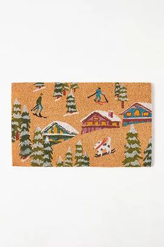 a door mat with skiers and houses on it