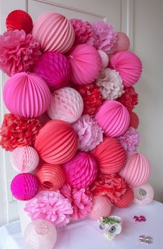 pink and red paper lanterns are arranged on a table