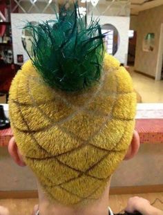 a man with a pineapple shaped haircut has green feathers on top of his head