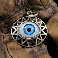 Handcrafted Solid 925 Sterling Silver All Seeing Eyeball w/Rays Pendant NOW: Choose between BLUE or BROWN eyeball! This is a funny take on the all seeing eye; instead of the classical eye of ra, this goofier version features a plastic craft eyeball surrounded by rays set in a solid sterling silver pendant. It's bound to spark a conversation wherever you go! We have added a brown eye as an option in the listing for more variety! I have included a photograph of the pendant next to a quarter for si Blue Engraved Amulet Style Jewelry, Blue Engraved Amulet Jewelry, Blue Sterling Silver Amulet Jewelry, Symbolic Blue Engraved Jewelry, Blue Oval Pendant Jewelry, Engraved, Blue Engraved Oval Pendant Jewelry, Symbolic Blue Round Jewelry, Symbolic Eye-shaped Silver Jewelry, Unique Silver Evil Eye Jewelry