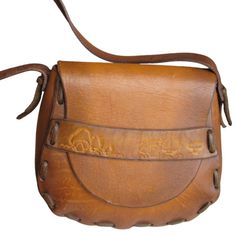 Fabulous Hippie Hobo Shoulder Bag In Saddle Leather With Flap Closure And Embossed Mushroom Accent. Very Clean, Appears To Be Unused. Melon Or Mandolin Shaped Strap Drop 13" Length 7" Depth 4.5" Width 9.5" Hand Stitched In The Usa Retro Leather Saddle Bag, Retro Hand-tooled Bags, Vintage Saddle Bag With Leather Backing, Vintage Saddle Bag With Leather Lining, Vintage Leather Saddle Satchel, Vintage Hand Tooled Leather Saddle Bag, Retro Leather Saddle Bag For Daily Use, Vintage Saddle Shoulder Bag With Adjustable Strap, Vintage Satchel Saddle Bag In Soft Leather