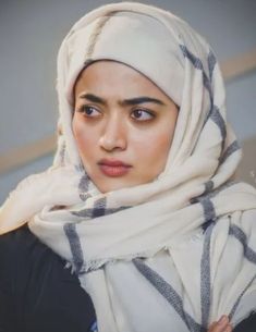 a woman wearing a headscarf and looking at the camera