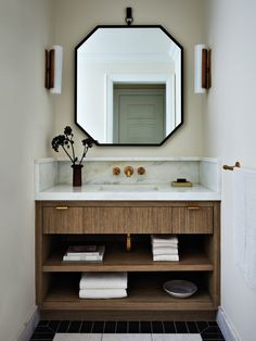 a bathroom vanity with a mirror above it and towels on the counter top next to it