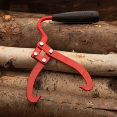 a red handled knife sitting on top of some logs