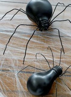 two black spider sculptures sitting on top of a wooden table